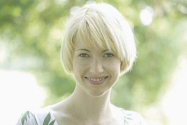 Deutschland, Bayern, Schaeftlarn, Nahaufnahme einer jungen Frau im Park, Porträt, lächelnd - TCF001786