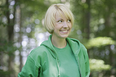 Deutschland, Bayern, Schaeftlarn, Nahaufnahme einer jungen Frau im Wald, lächelnd - TCF001776