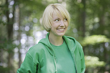 Germany, Bavaria, Schaeftlarn, Close up of young woman in forest, smiling - TCF001776