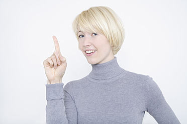 Close up of young woman against white background, portrait, smiling - TCF001762