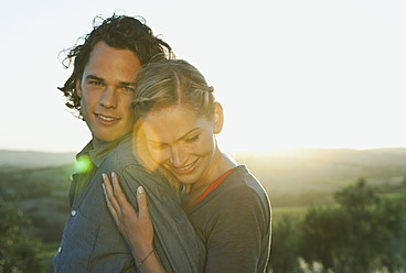 Italy, Tuscany, Young woman embracing man at dusk - PDF000200