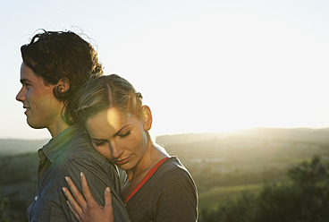 Italy, Tuscany, Young woman embracing man at dusk - PDF000202