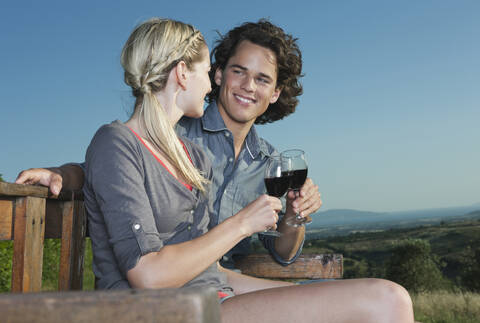 Italien, Toskana, Junges Paar stößt mit Weingläsern an, lizenzfreies Stockfoto