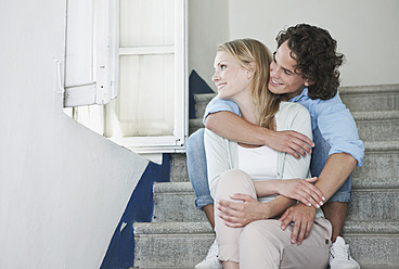 Italy, Tuscany, Young couple sitting on stairway of hotel - PDF000253