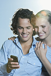 Italien, Toskana, Nahaufnahme eines jungen Paares, Mann benutzt Mobiltelefon - PDF000281