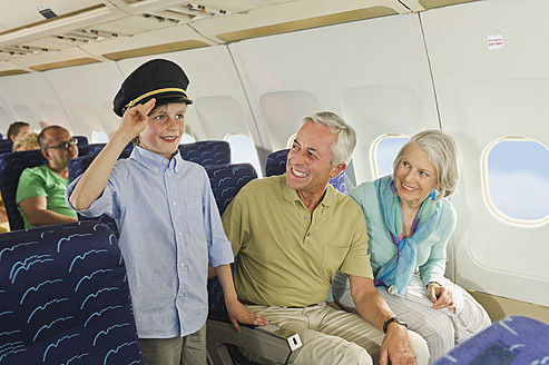 Germany, Munich, Bavaria, Boy wearing captains hat and people looking in economy class airliner - WESTF017241