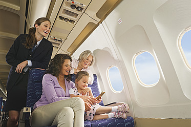 Deutschland, München, Bayern, Menschen mit Mobiltelefon in der Economy Class eines Flugzeugs - WESTF017252