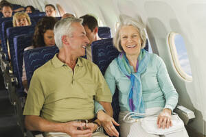 Deutschland, München, Bayern, Gruppe von Passagieren in der Economy Class eines Flugzeugs, lächelnd - WESTF017263