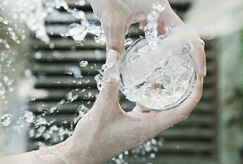 Italien, Toskana, Magliano, Nahaufnahme der Hand einer Frau, die ein Wasserglas füllt - WESTF017282