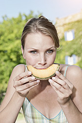 Italien, Toskana, Magliano, Nahaufnahme junge Frau isst Honigmelone, Porträt - WESTF017437