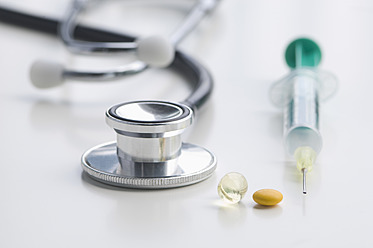 Stethoscope, syringe and tablets on white background, close up - CRF002104