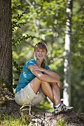 Deutschland, Oberbayern, Junge Frau unter Baum ruhend, lächelnd, Porträt - MAEF003845