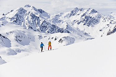 Austria, Stuben, Young couple doing telemark skiing on arlberg mountain - MIRF000299
