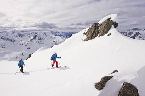 Austria, Stuben, Young couple doing telemark skiing on arlberg mountain stock photo