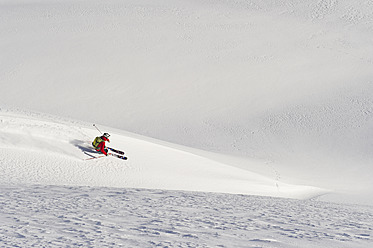 Austria, Zuers, Young man doing telemark skiing on Arlberg mountain - MIRF000335