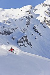 Austria, Zuers, Young man doing telemark skiing on Arlberg mountain - MIRF000339