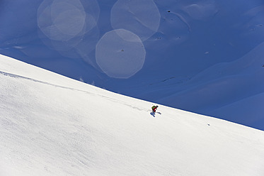 Austria, Zuers, Young man doing telemark skiing on Arlberg mountain - MIRF000342