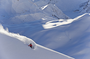 Austria, Zuers, Young man doing telemark skiing on Arlberg mountain - MIRF000344