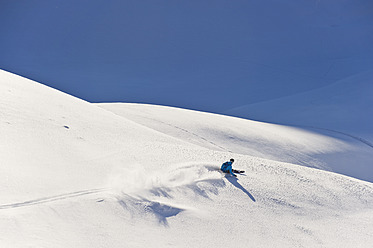 Austria, Zuers, Young man doing telemark skiing on Arlberg mountain - MIRF000350