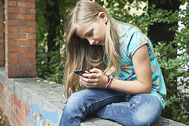 Deutschland, Berlin, Mädchen benutzt Mobiltelefon - WESTF017479