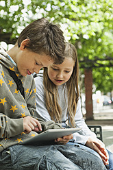 Deutschland, Berlin, Junge und Mädchen benutzen digitales Tablet - WESTF017489