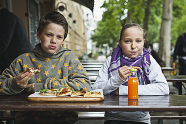 Deutschland, Berlin, Junge und Mädchen essen Pizza im Cafe - WESTF017507