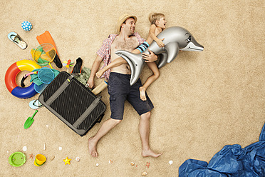 Deutschland, Vater und Sohn mit Spielzeug und Gepäck am Strand - BAEF000294