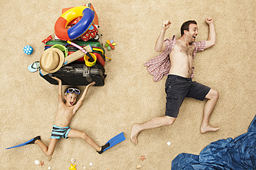 Deutschland, Vater und Sohn mit Spielzeug und Gepäck am Strand - BAEF000295