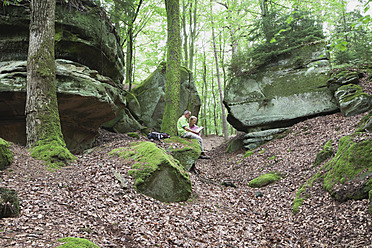 Germany, Rhineland-Palatinate, Mature couple reading map in nature park - GWF001595