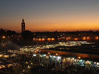 Marokko, Marrakesch, Menschen auf dem Djemaa el Fna Platz mit der Koutoubia Moschee bei Nacht - BSCF000060