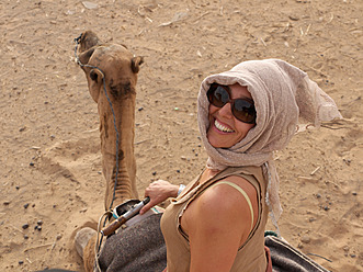 Marokko, Merzouga, Ältere Frau auf Kamel sitzend in der Wüste Erg Chebbi - BSCF000069