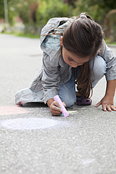 Germany, Bavaria, Huglfing, Girl drawing on street with chalk - RIMF000024