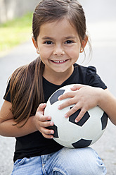 Germany, Bavaria, Huglfing, Girl with ball on street, smiling, portrait - RIMF000023