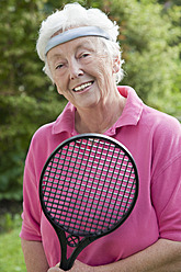 Deutschland, Bayern, Huglfing, Seniorin mit Badmintonschläger, lächelnd, Porträt - RIMF000012