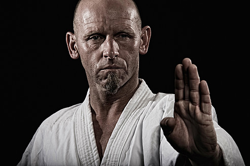 Germany, Bavaria, Mature man doing karate, close up - DK000183