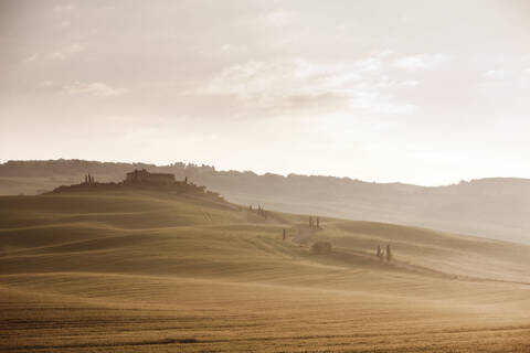 Italien, Toskana, Blick auf ein Bauernhaus bei Sonnenaufgang, lizenzfreies Stockfoto