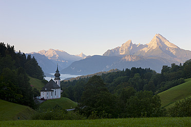 Germany, Bavaria, Berchtesgaden, View of chapel with mountains in background at sunrise - FLF000012