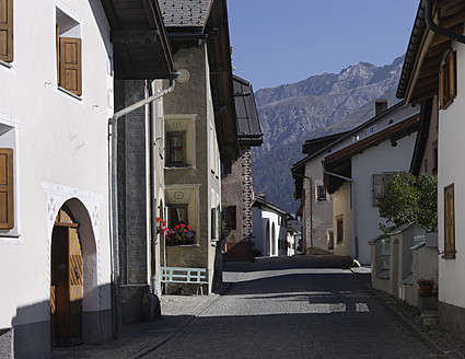 Schweiz, Graubünden, Oberengadin, Blick auf Straße mit Dorfhäusern - TCF001823