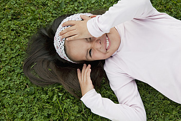 Germany, Bavaria, Huglfing, Girl lying on grass in garden, smiling, portrait - RIMF000041