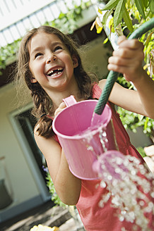 Germany, Bavaria, Girl gardening with watering can, smiling - WESTF017703