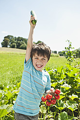 Deutschland, Bayern, Junge hält Gemüse im Garten, lächelnd, Porträt - WESTF017717