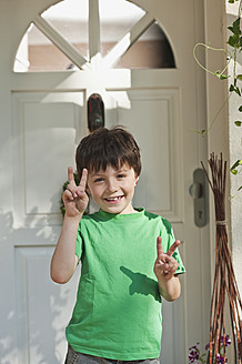 Germany, Bavaria, Boy showing peace sign, smiling, portrait - WESTF017723