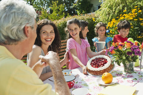 Deutschland, Bayern, Familie bei Kaffee und Kuchen im Garten, lächelnd, lizenzfreies Stockfoto