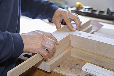 Germany, Upper Bavaria, Schaeftlarn, Carpenter fixing wood - TCF001908