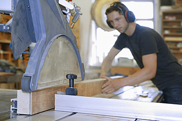 Germany, Upper Bavaria, Schaeftlarn, Carpenter working on buzz saw - TCF001911