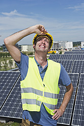 Deutschland, München, Techniker in Solaranlage, lächelnd - WESTF017839