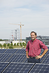 Deutschland, München, Älterer Mann in Solaranlage stehend, lächelnd, Porträt - WESTF017868