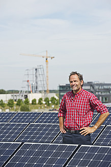 Deutschland, München, Älterer Mann in Solaranlage stehend, lächelnd, Porträt - WESTF017868