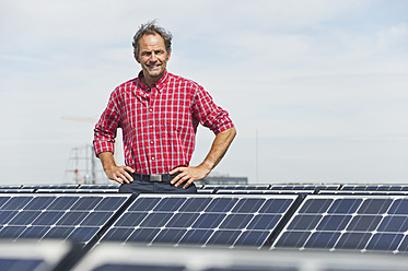 Deutschland, München, Älterer Mann in Solaranlage stehend, lächelnd, Porträt - WESTF017869