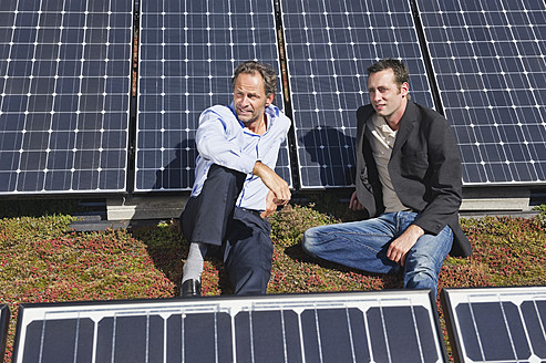 Deutschland, München, Zwei Männer sitzen und entspannen sich in einer Solaranlage - WESTF017898